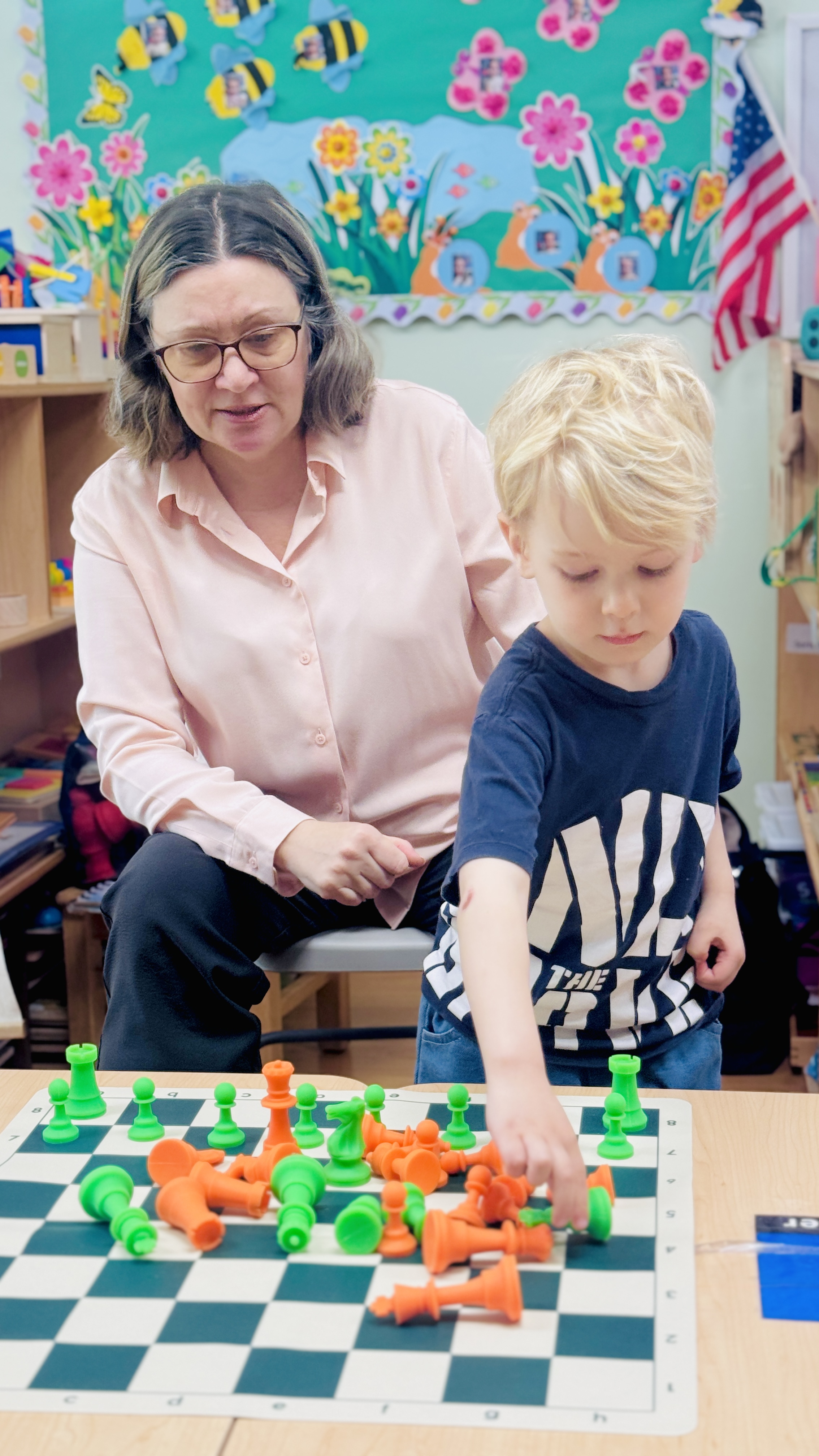 Teacher helping boy learn chess strategy