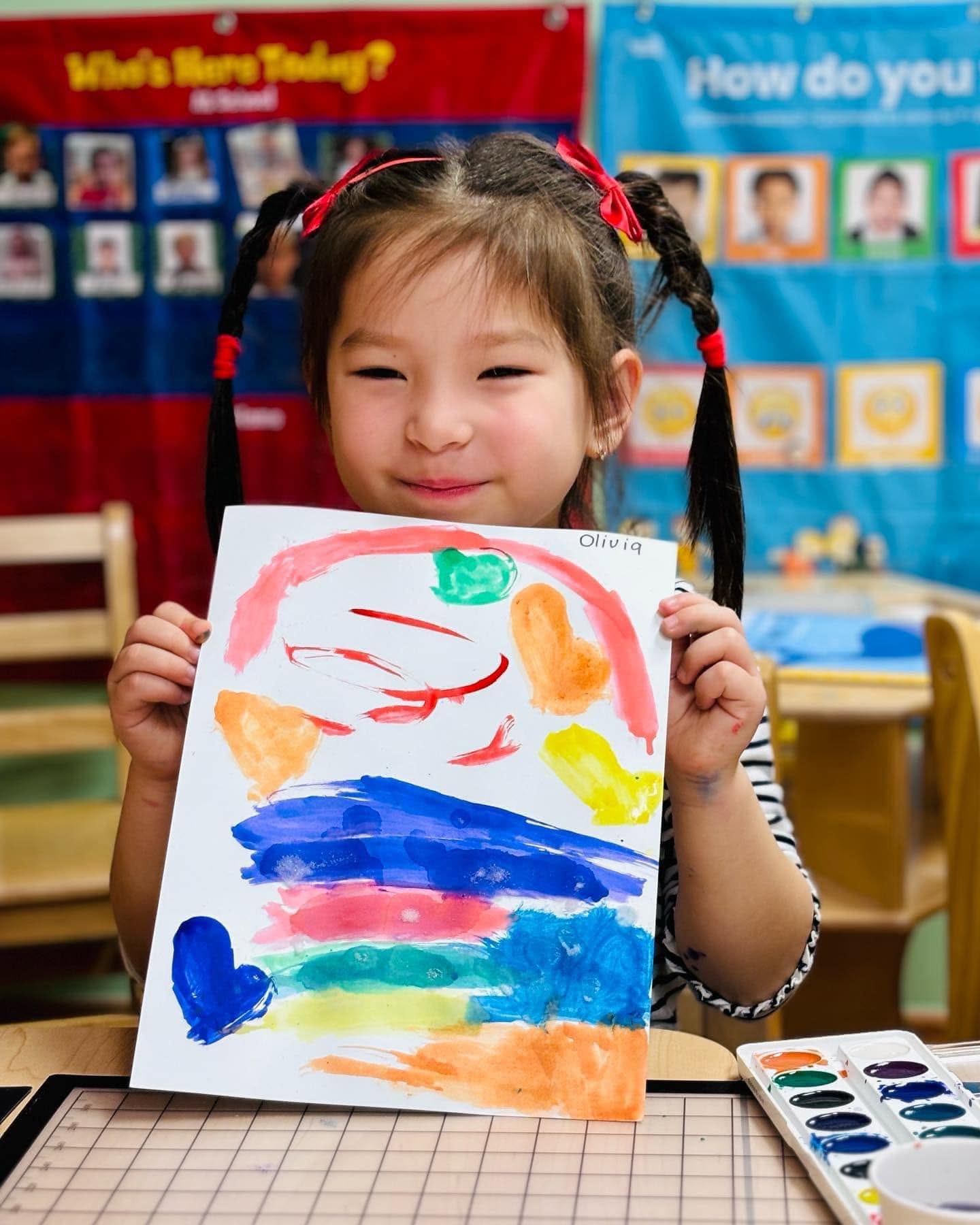 Girl proudly showing her watercolor painting