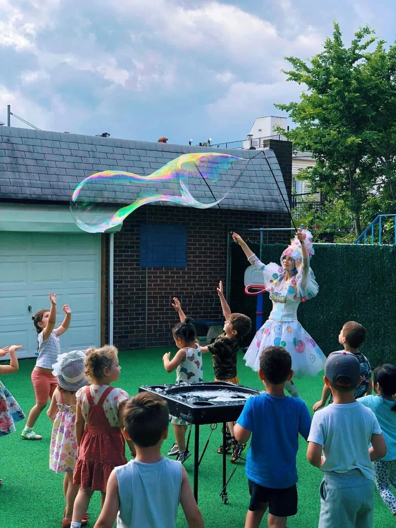 Children enjoying a giant bubble show in the private backyard