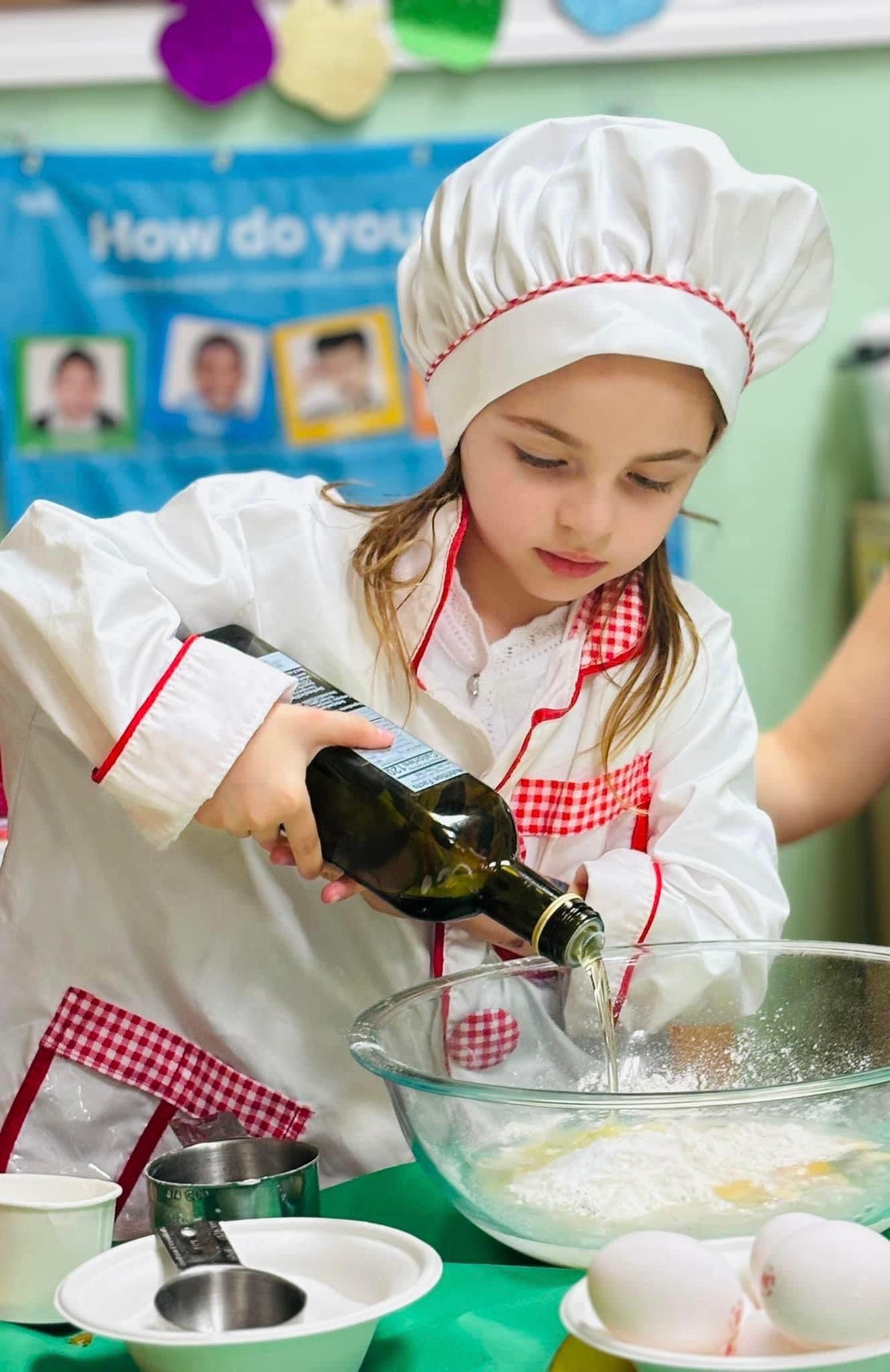 Child in a chef hat during a cooking class