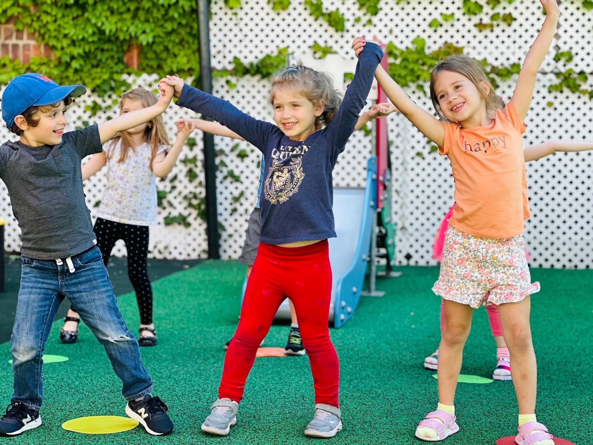Children holding hands and stretching together on the playground