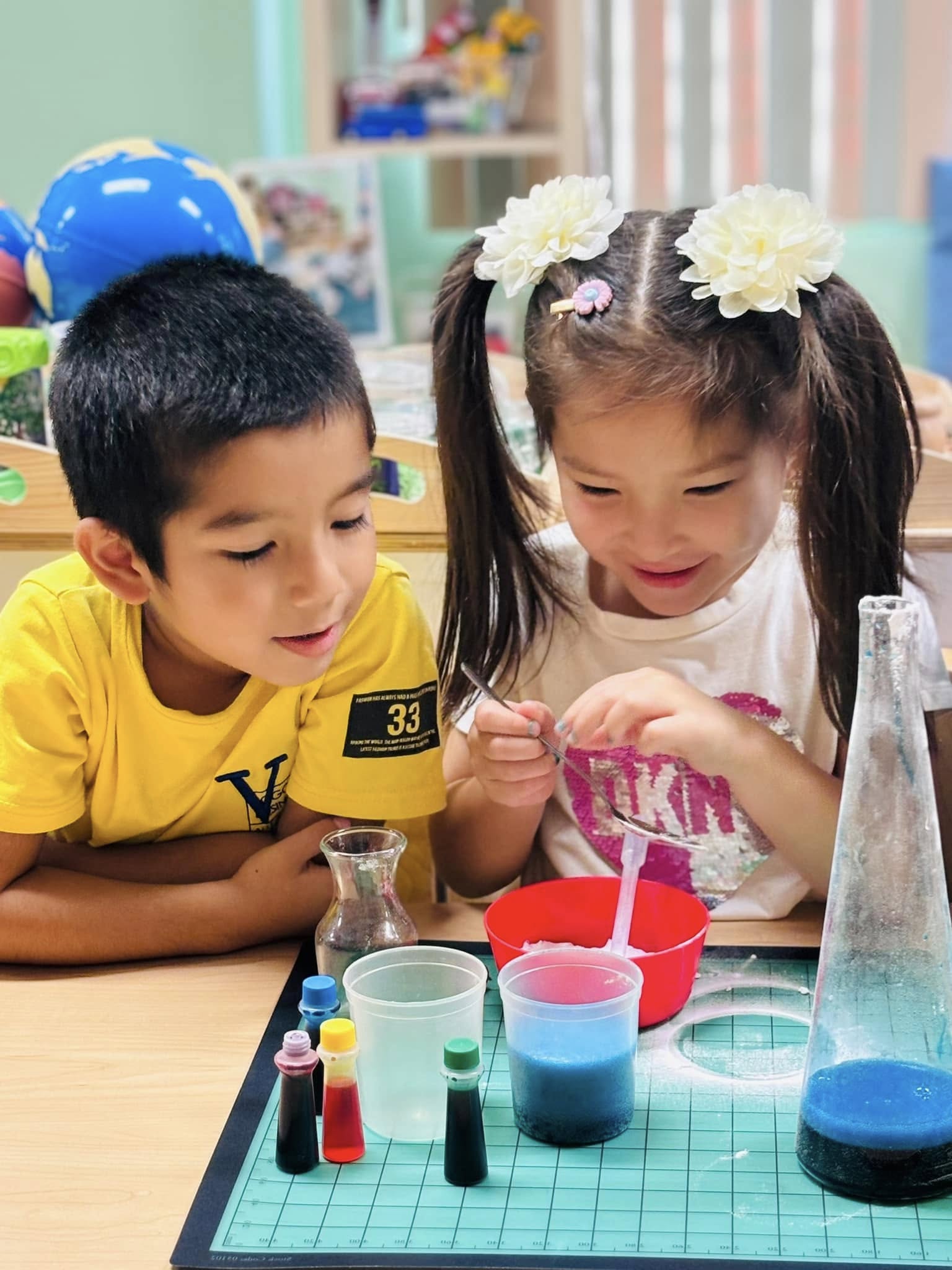 A boy and girl mixing colored liquids in a hands-on science experiment